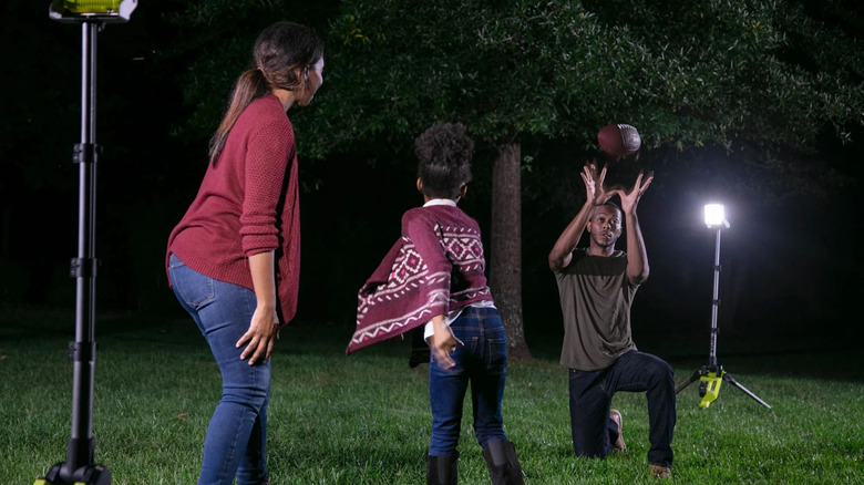 Family plays games using a Ryobi ONE+ 18V Tripod Stand Light