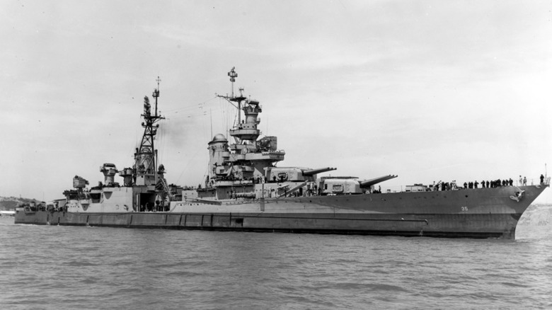 Black & white photo of USS Indianapolis sailing as sailors walk around its deck