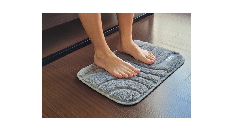 A Ruggie smart mat with a pair of legs resting on it