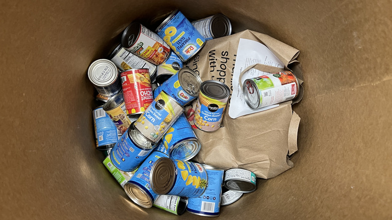 High-angle view of canned goods and other food items in a food bank donation bin.