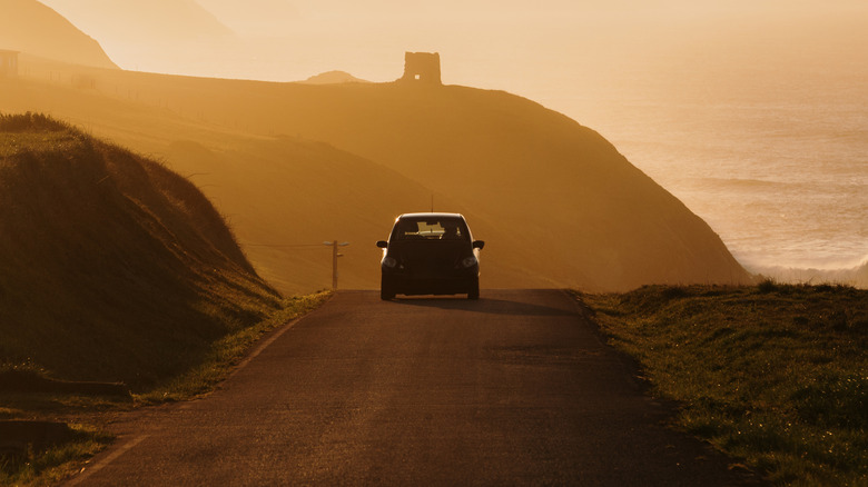 A car driving down a hill in the sunset