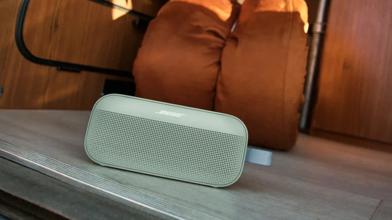 A sage green Bose SoundLink Flex speaker on the floor