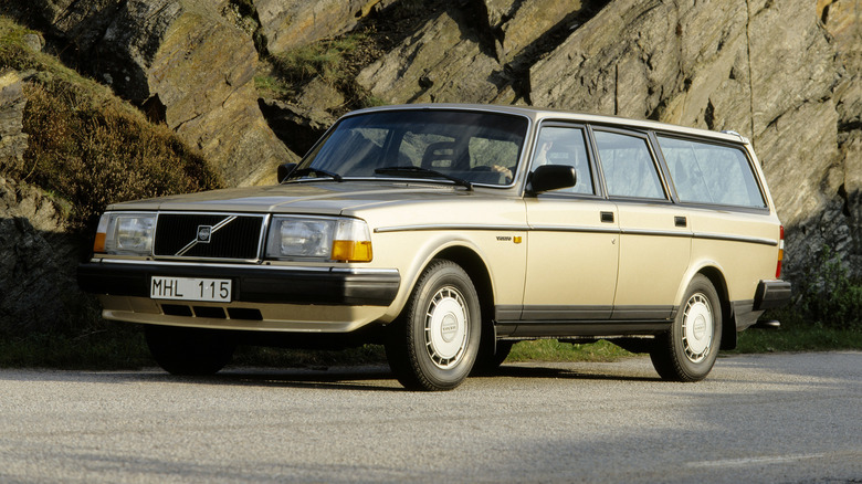 Volvo 240 parked by a cliff face