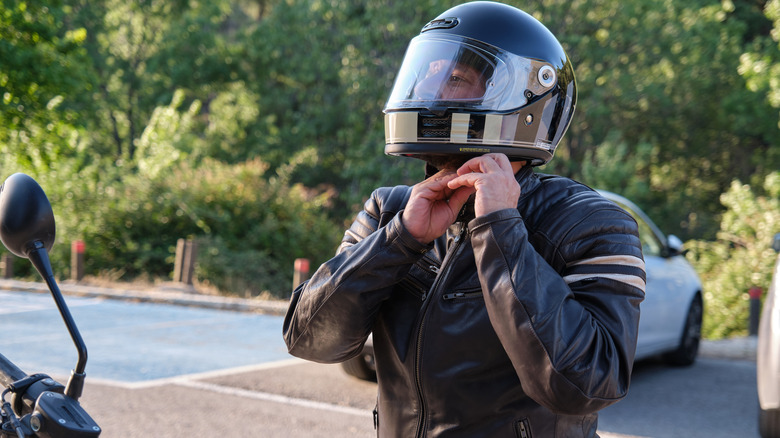Motorcycle rider strapping on his helmet.