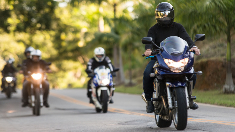 A group of motorcycle riders on the road.