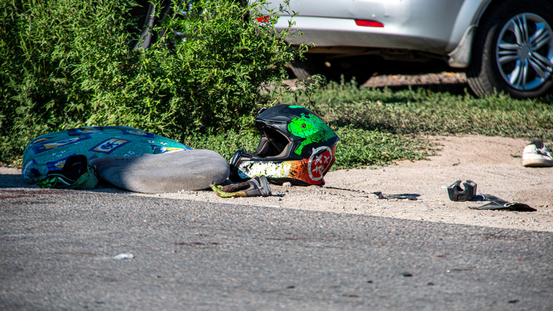 A biker helmet and clothes on the road following a crash.