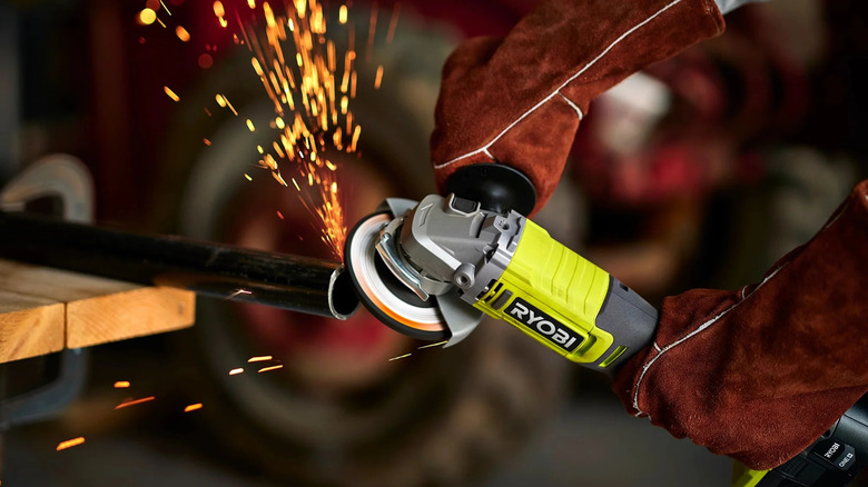 Sparks flying while a worker uses a Ryobi angle grinder
