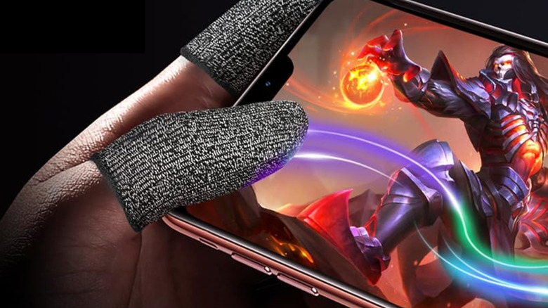 Hand wearing finger sleeves while gaming on phone.