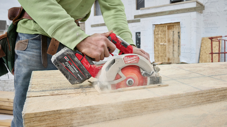 A worker using a Milwaukee circular saw.