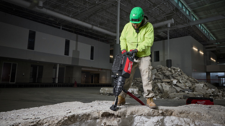 A worker using a Milwaukee demolition hammer,