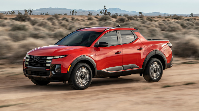 A side on shot of a red 2025 Hyundai Santa Cruz driving