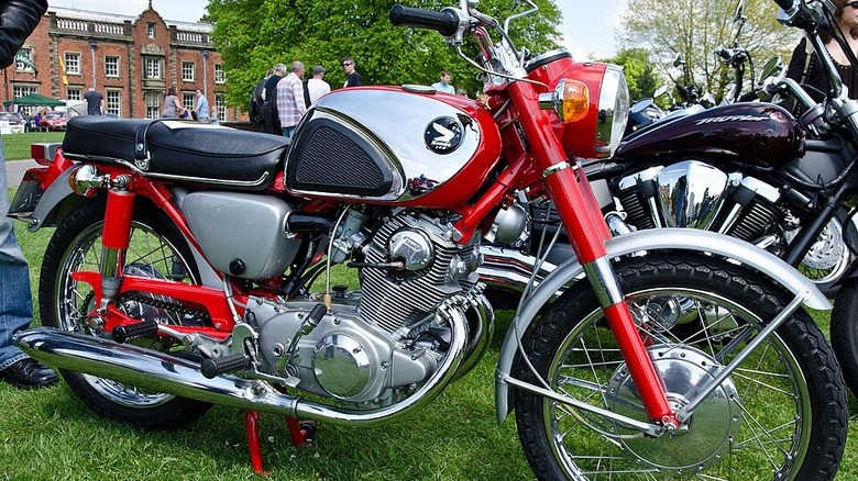 Red and silver honda cb77 super hawk near other bikes