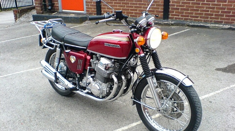 maroon 1969 honda cb750 in parking lot