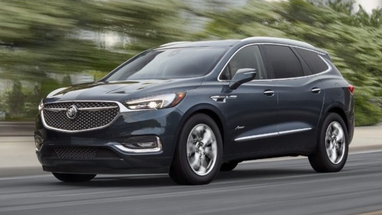 A dark gray 2021 Buick Enclave driving on a city street.