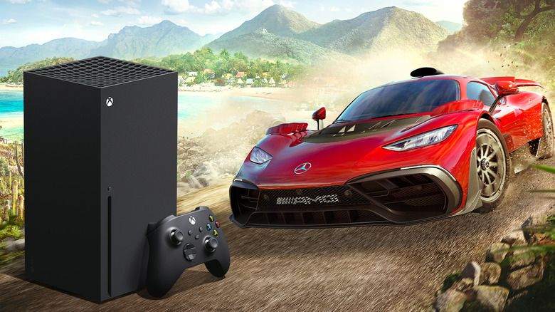 An Xbox Series X console displayed next to a red racing car.