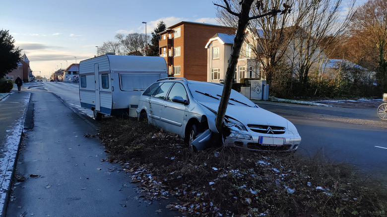 A car crashed into a tree while hauling a trailer