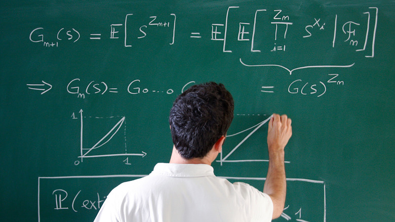 A man doing math equations on a chalkboard