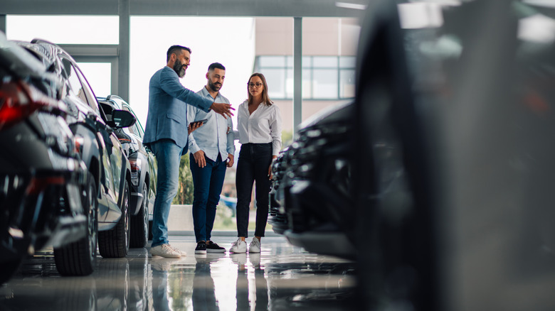 A salesman making a pitch at a car dealership