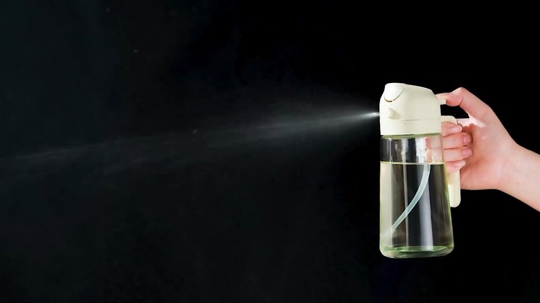 Oil dispenser spraying oil