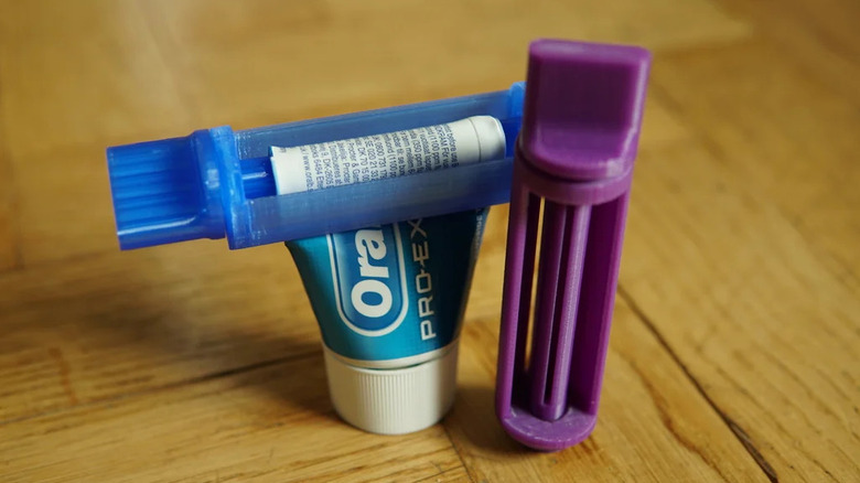 Two toothpaste squeezers, one with toothpaste in it