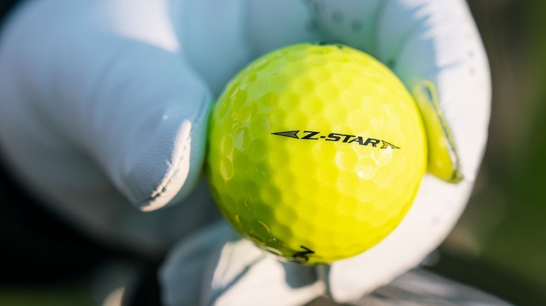 Hand holding Srixon Z-star golf ball
