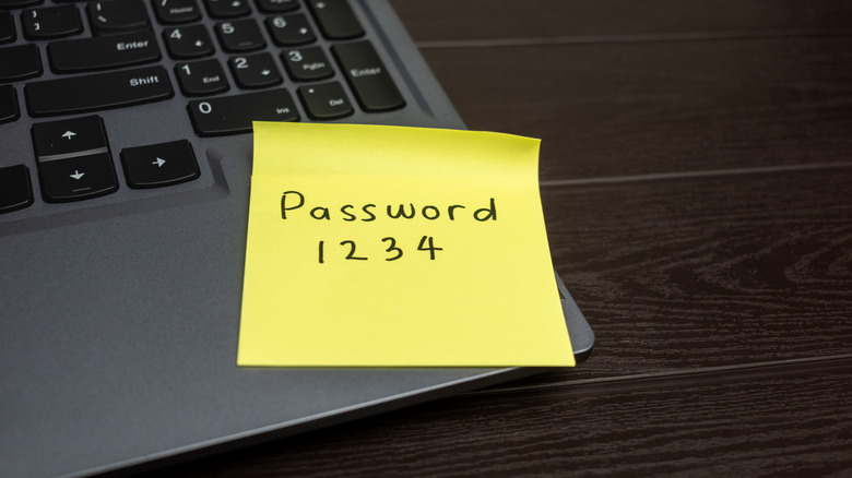 Password written on a yellow sticky note tacked on a laptop