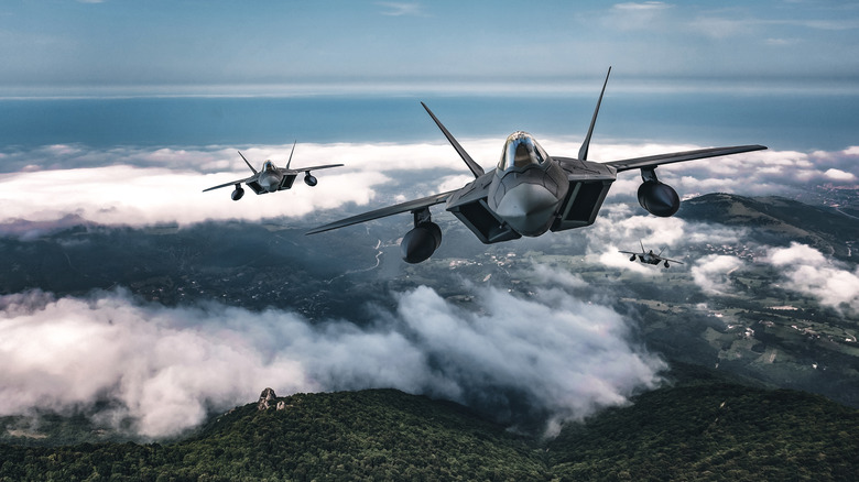 fighter jets flying over clouds