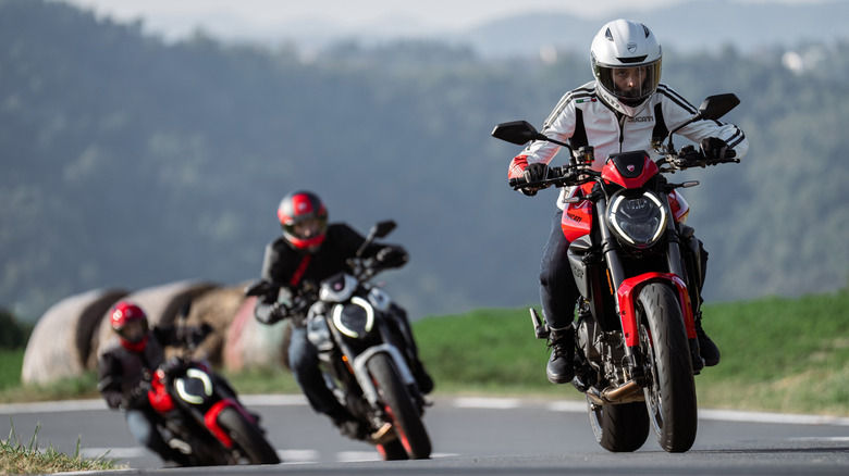 Group of new Ducati Monsters being ridden on the track