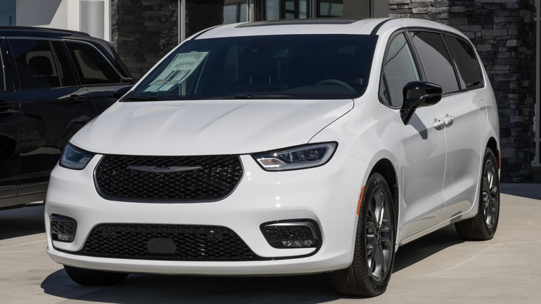 A white Chrysler Pacifica minivan in the "Select" trim on display at a dealership.