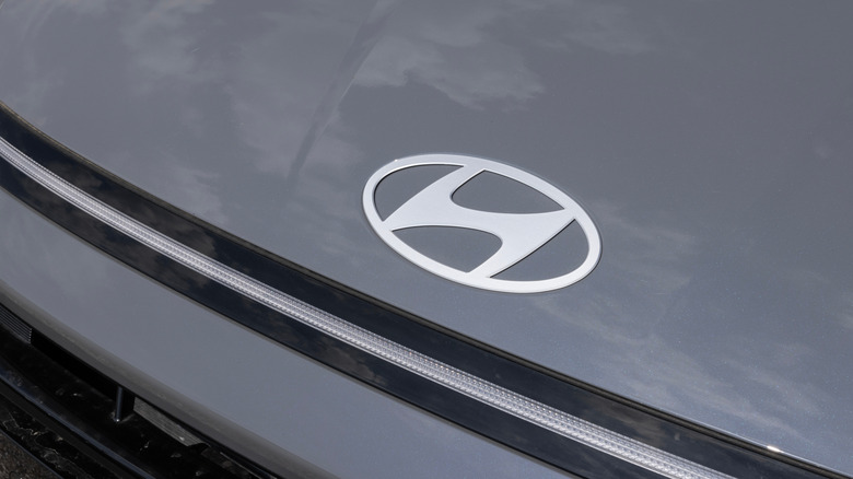 A silver Hyundai logo on the bonnet of an unidentified black car.