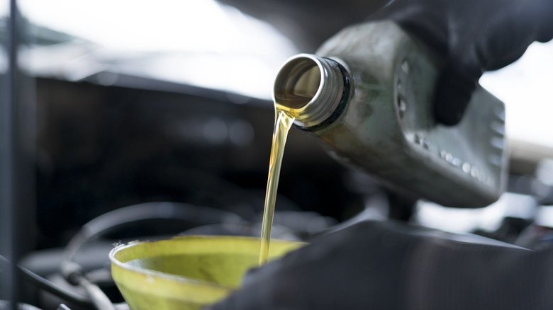 Mechanic topping up engine oil