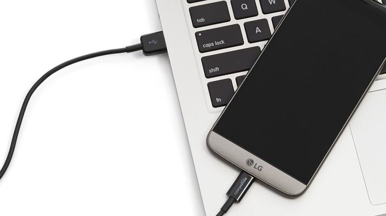 AmazonBasics USB-A to USB-C cable connecting a smartphone to a laptop