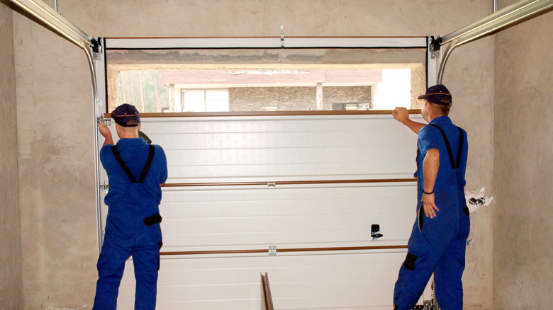 contractors insulating a garage door