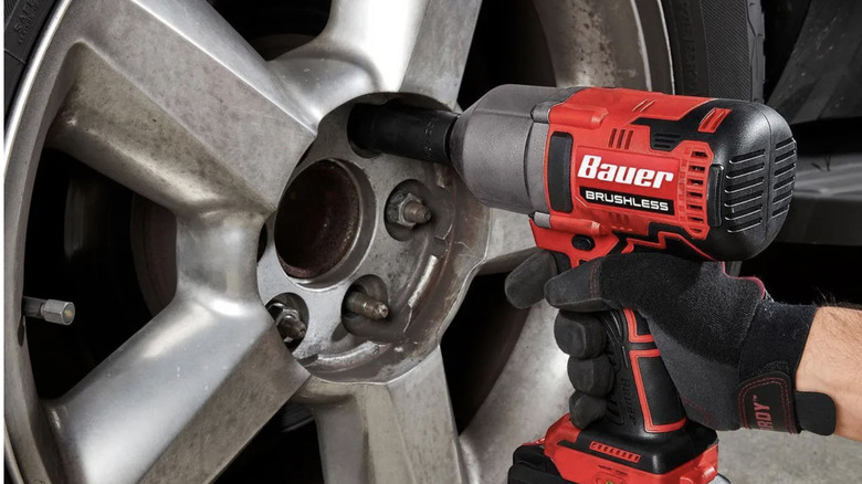 Gloved hand using Bauer impact wrench on wheel lug