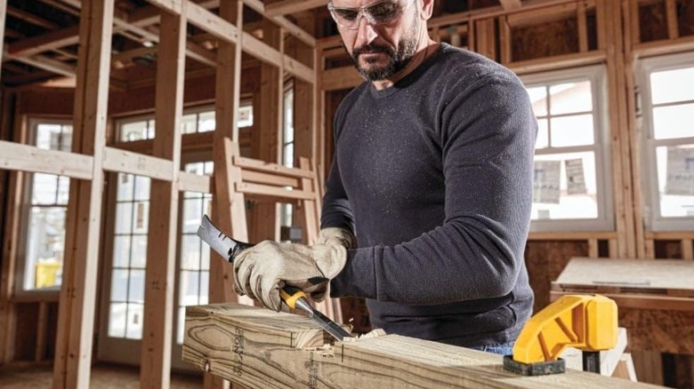 a person using a dewalt pro wood chisel to make a joint in a piece of lumber