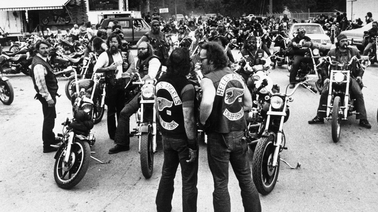 Ralph "Sonny" Barger, President of the Hell's Angels and members from the New York chapter standing in front of a group of Hell's Angels members on motorcycles.