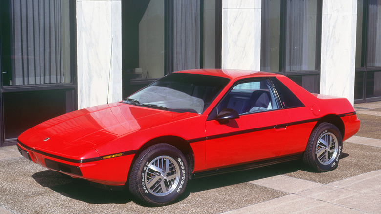red Pontiac Fiero parked outside building