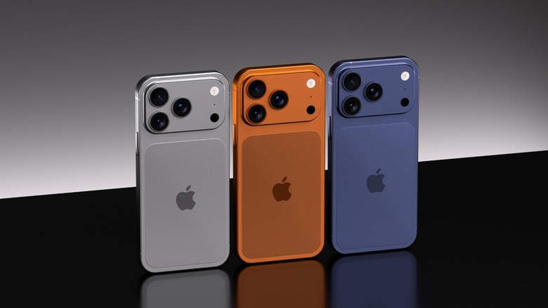 iPhone 17 Pro devices in grey, orange, and blue on a black surface