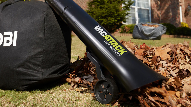 A Ryobi leaf vacuum picking up leaves out of a yard
