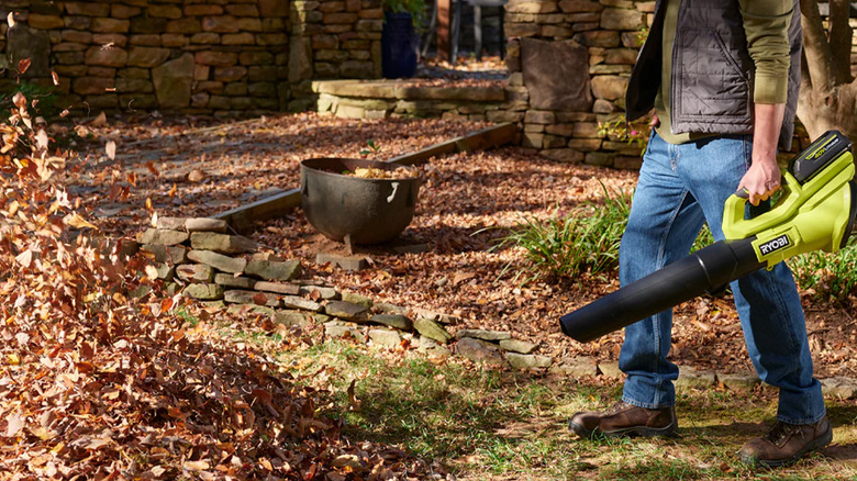 A person blowing leaves with a Ryobi leaf blower