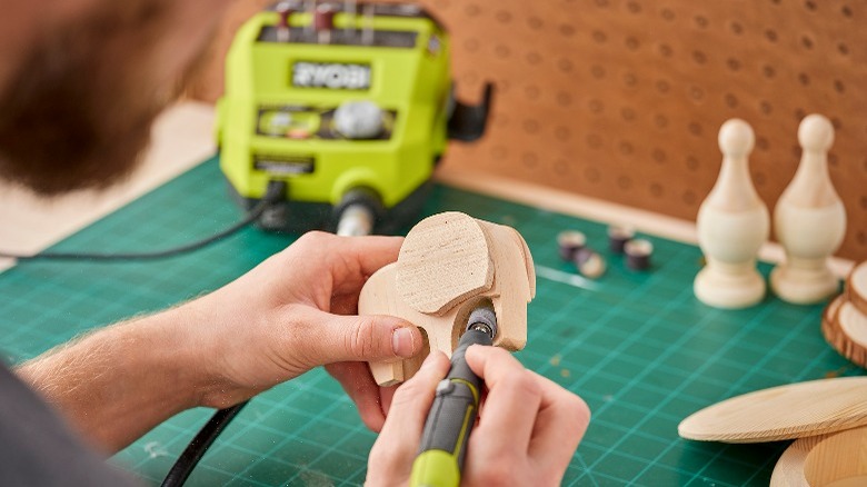 person carving a wooden Elephant