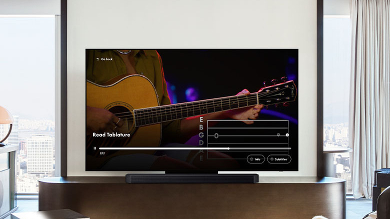 A Samsung Smart TV with a sound bar in front of it in a living room.