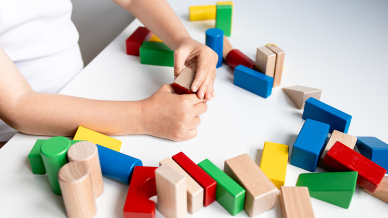 Close up of a child playing with wooden blocks