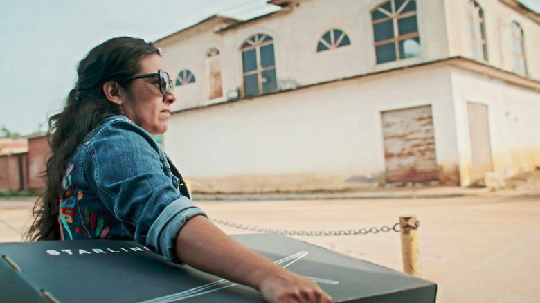 Woman carrying a box with Starlink dish