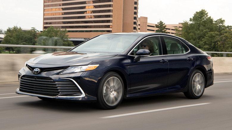 Dark blue 2021 Toyota Camry driving on an urban road