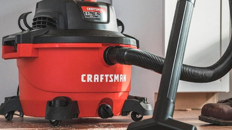 A person using a Craftsman shop vacuum.