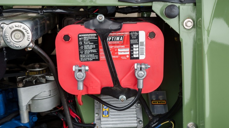 A green car with an Optima car battery installed.
