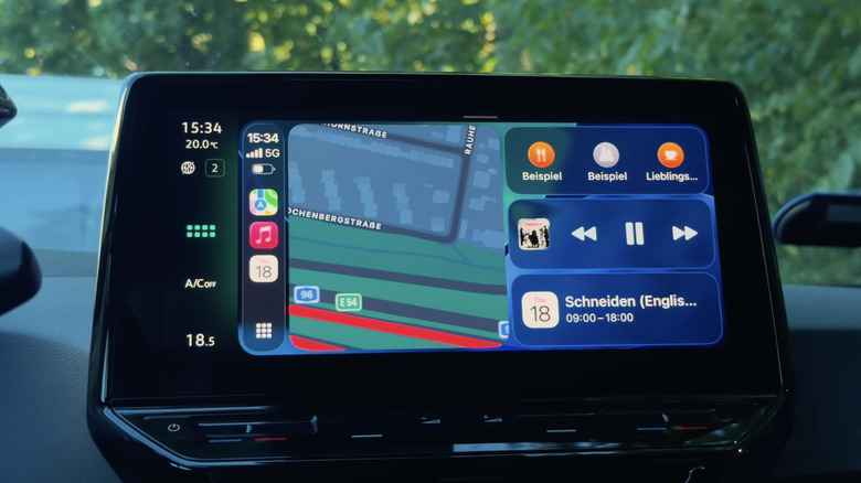 A car's central infotainment screen showcasing iOS CarPlay widgets.