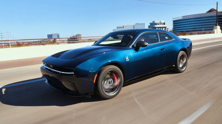 Front 3/4 action shot of a Dodge Charger Daytona Scat Pack with mountains in the background