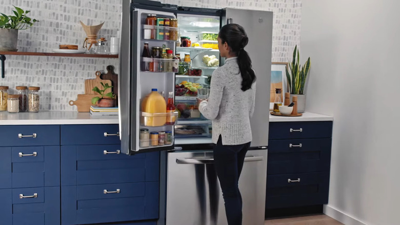 Woman standing in front of GE GNE25JYKFS installed in kitchen